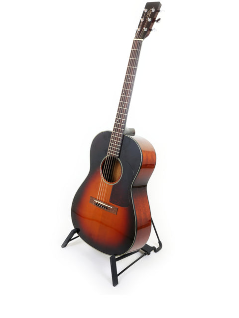 A 2005 K. Yairi G-1F guitar on a stand, set against a bright white background.
