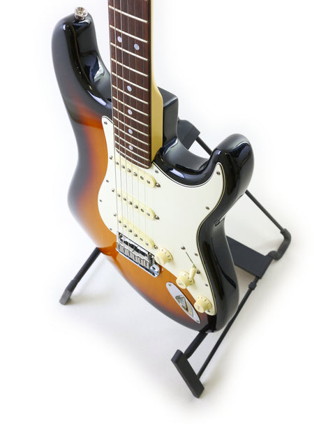 A 2006 Fender 60th Anniversary American Stratocaster displayed on a stand with a bright white backdrop.