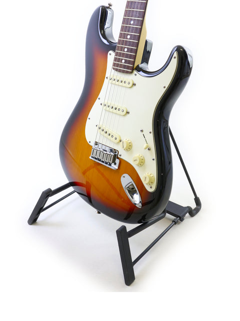 A 2006 Fender 60th Anniversary American Stratocaster displayed on a stand with a dark black backdrop.