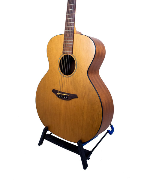A 2008 Furch S40-CM guitar elegantly positioned on a stand with a bright white backdrop.
