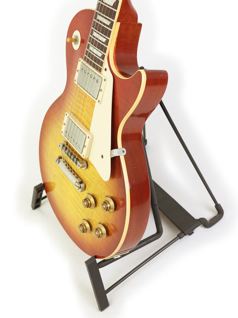 A_2008_Gibson_Custom_Shop_58_Les_Paul_Standard_Flame_Top_guitar_displayed_on_a_stand_with_a_white_backdrop.