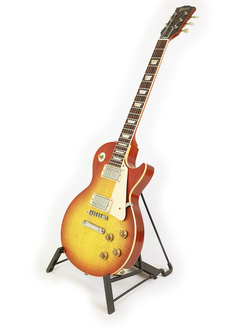 A 2008 Gibson Custom Shop '58 Les Paul Standard Flame Top guitar elegantly positioned on a stand for display.