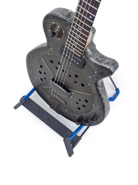 A 2009 National Reso-Phonic Polychrome Tricone Resonator guitar displayed on a blue stand, highlighting its artistic features.