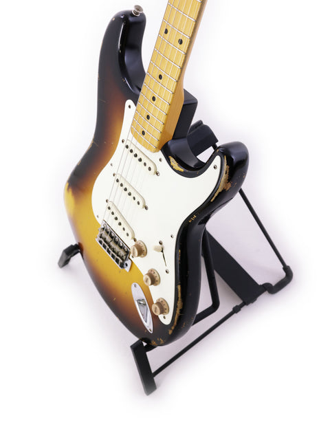  A 2015 Fender Jason Smith Masterbuilt '57 Reissue Stratocaster displayed on a stand with a plain white backdrop.
