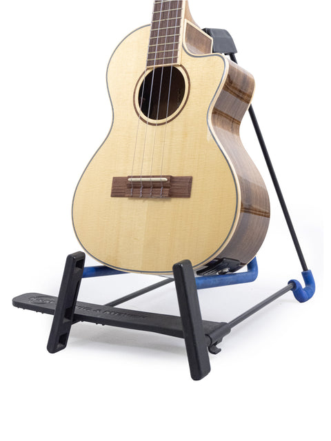A 2019 Kala KA-SKT GE-C Tenor Ukulele with pickup displayed on a stand, highlighting its sleek design and vibrant finish.
