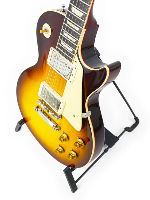 A 2020 Gibson Custom Shop 60th Anniversary 1960 Les Paul Standard guitar resting on a stand, highlighting its craftsmanship.