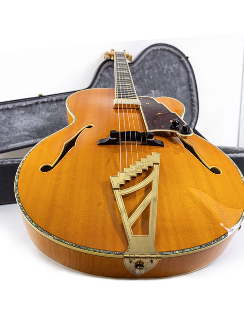 A D’Angelico New Yorker Series Excel EXL-1DP guitar lying in its case on the floor, emphasizing its sleek and classic appearance.