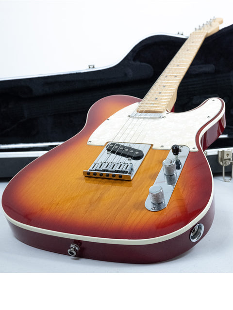 A Fender American Deluxe Telecaster guitar displayed on its case, highlighting its elegant features and quality.