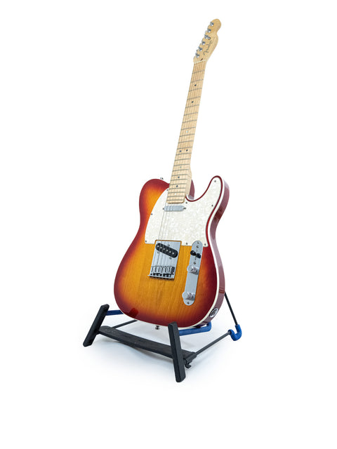 A Fender American Deluxe Telecaster guitar resting on a stand, set against a simple white background.