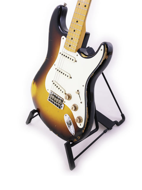 A Fender Jason Smith Masterbuilt Stratocaster '57 Reissue guitar elegantly positioned on a stand with a white background.
