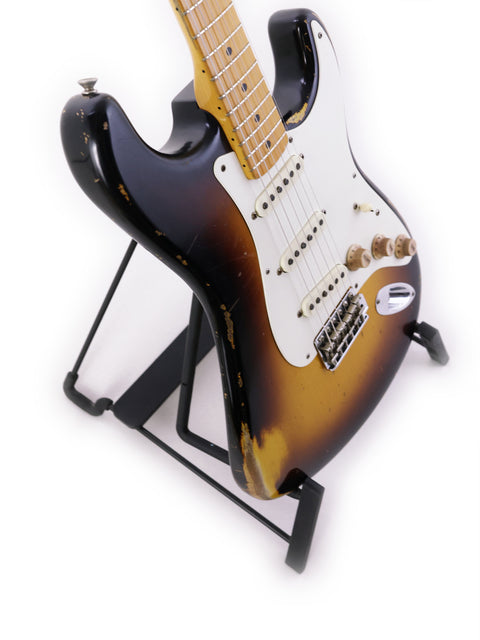 A Fender Jason Smith Masterbuilt Stratocaster '57 Reissue guitar on a stand, showcased with a simple white background.
