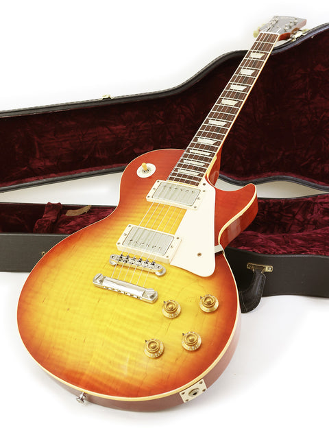 A Gibson '58 Les Paul Standard Flame Top guitar in a case, highlighting its 50th anniversary and exquisite craftsmanship.