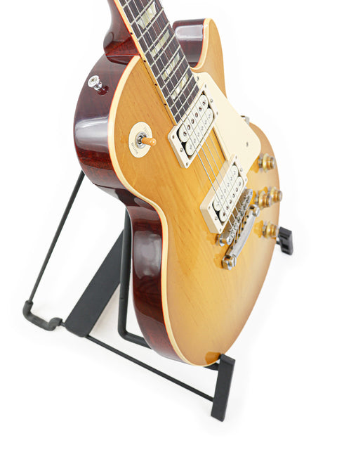 A Gibson Custom Shop '58 Les Paul Standard R/I guitar resting on a stand, set against a plain white background.
