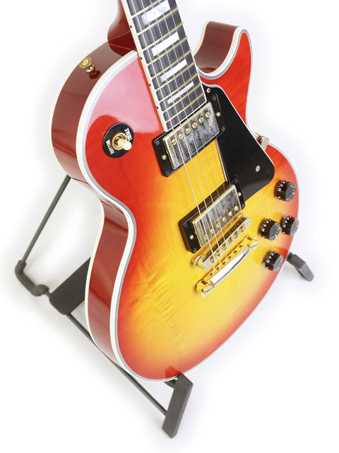 A Gibson Custom Shop Les Paul Custom guitar displayed elegantly on a stand, showcasing its craftsmanship and design.