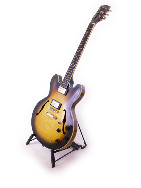 A Gibson ES-335 guitar from 2006 rests elegantly on a stand, showcasing its classic design and craftsmanship.