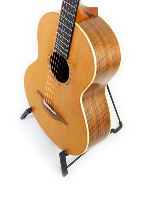 A Lowden S-35 1 of 1 Prototype guitar elegantly positioned on a stand with a stark white background.