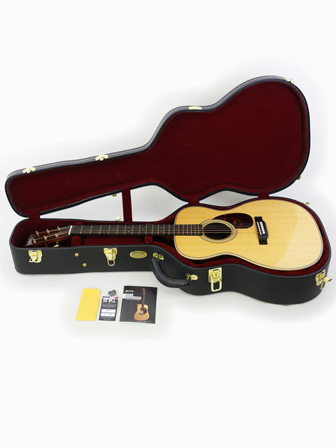 A Martin 000-28 Modern Deluxe guitar nestled in its case, highlighting the instrument's beauty and quality from USA 2022.