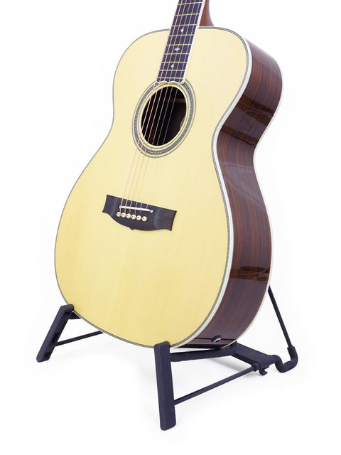 A Maton Custom Shop Classic guitar on a stand against a clean white background, showcasing its elegant design.