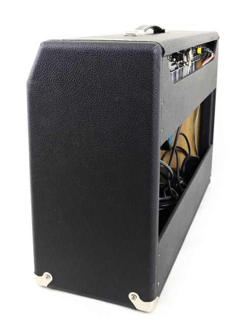 A black Achillies Vibrolux Reverb Combo Amp displayed on a white background, emphasizing its elegant and contemporary look.