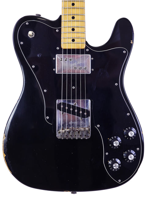 A black Fender Telecaster Custom electric guitar with a yellow pickguard, showcasing its classic 1978 design.