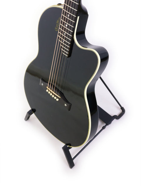 A black Gibson Chet Atkins SST guitar from 1998 rests on a stand, contrasting beautifully with the white background.