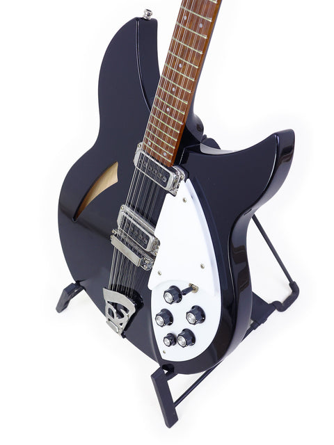 A black Rickenbacker 330 12-string guitar with a white pick guard, capturing the essence of modern design and musical heritage.