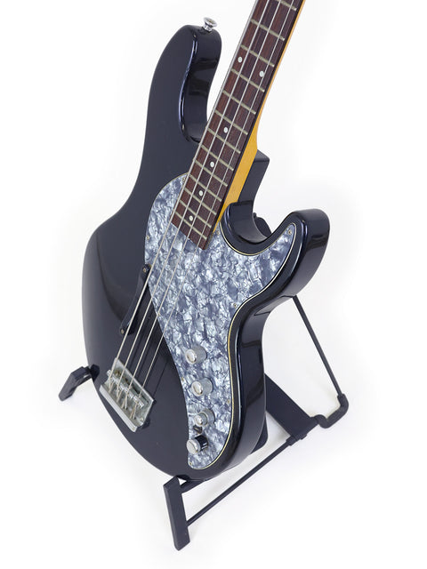 A black bass guitar with a minimalist white background, representing the Line 6 Variax Bass, crafted in Korea, 2004.