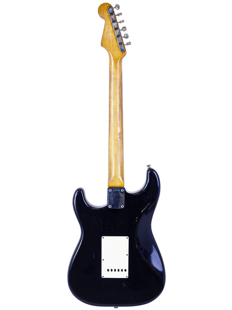 A black electric guitar with a wooden body, exemplifying the classic style of the 1963 Fender L-Series Stratocaster.

