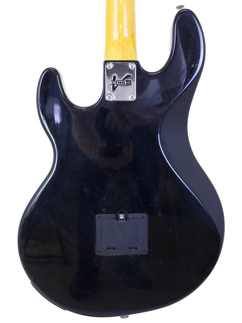 A black electric guitar with a yellow neck, featuring the Line 6 Variax Bass model from Korea, year 2004.