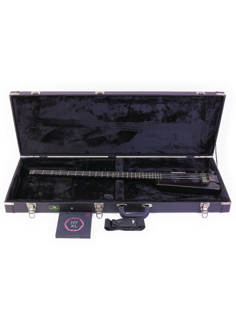 A black guitar case holds a classic 1982 Steinberger L2 Bass, ready for its next jam session.