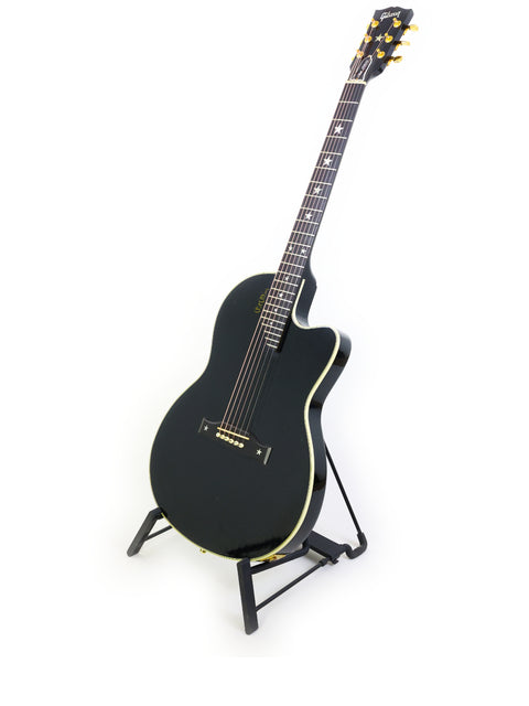 A black guitar, the Gibson Chet Atkins SST from 1998, elegantly displayed on a stand with a bright white backdrop.