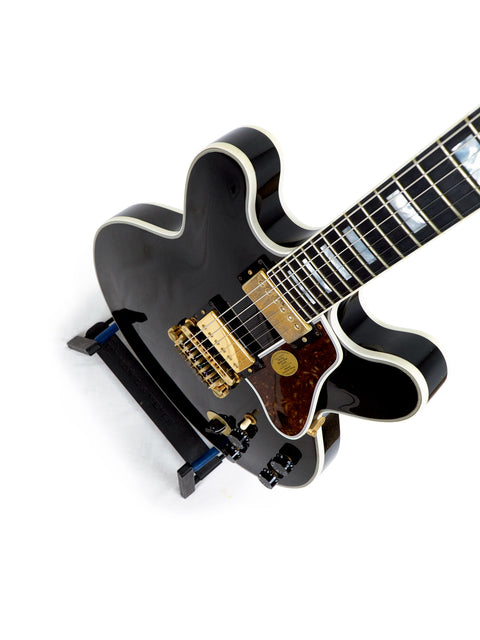 A black guitar with a white pickguard, the Gibson Lucille, signed by BB King and Eric Clapton, produced in the USA, 2000.