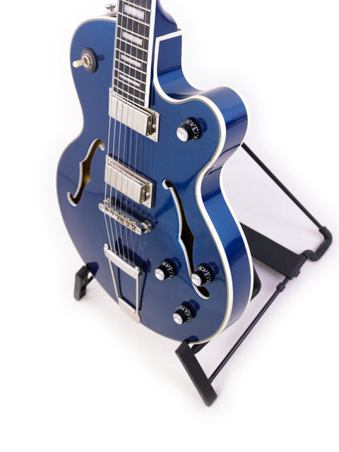A blue Epiphone UpTown Kat ES guitar on a stand against a clean white background.