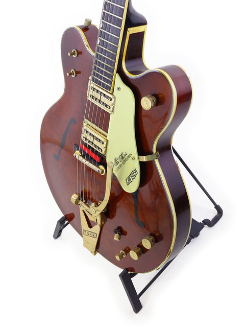 A classic 1967 Gretsch 6122 Chet Atkins guitar showcasing a wooden body and a luxurious gold headstock.