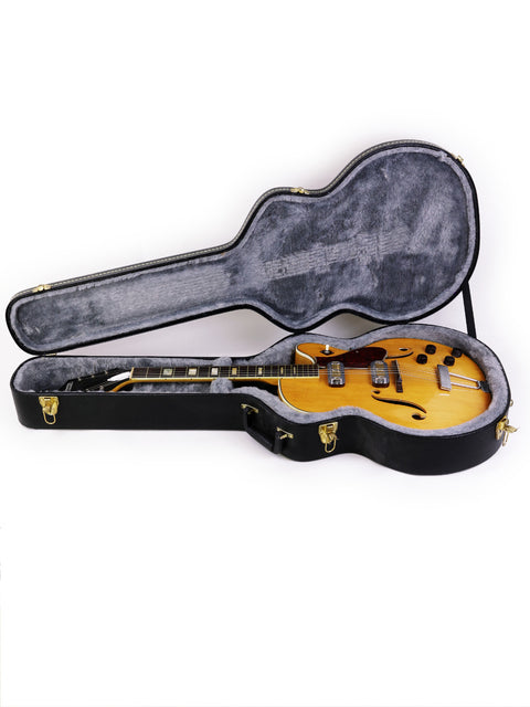A classic Harmony H71 Meteor guitar case with a striking yellow guitar inside, perfect for any guitarist's collection.