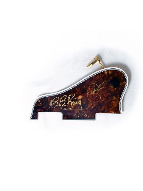 A close-up of a Gibson Lucille guitar showcasing a gold signature by BB King and Eric Clapton, made in the USA, 2000.
