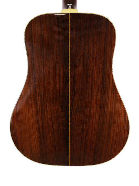 A close-up of the wooden back of a 1974 Guild D-50 Bluegrass Special acoustic guitar, highlighting its rich texture.