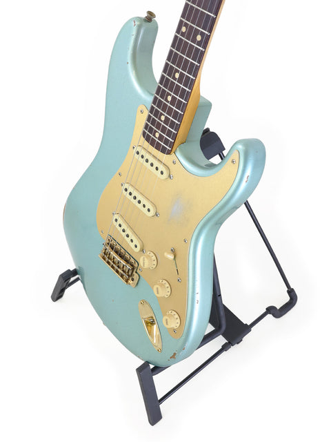 A green Fender Custom Shop Ltd Poblano Partscaster electric guitar displayed on a stand, USA 2020 model.