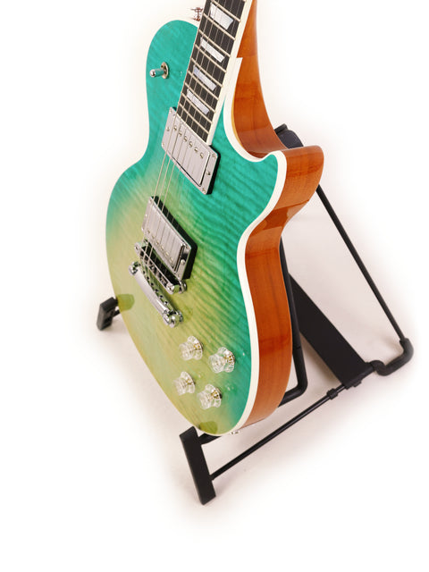  A green Gibson Les Paul HP guitar elegantly positioned on a stand, highlighted by a simple white background.