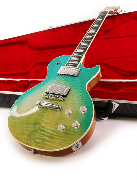 A green Gibson Les Paul HP guitar from 2019, resting in a vibrant red case, showcasing its unique color combination.