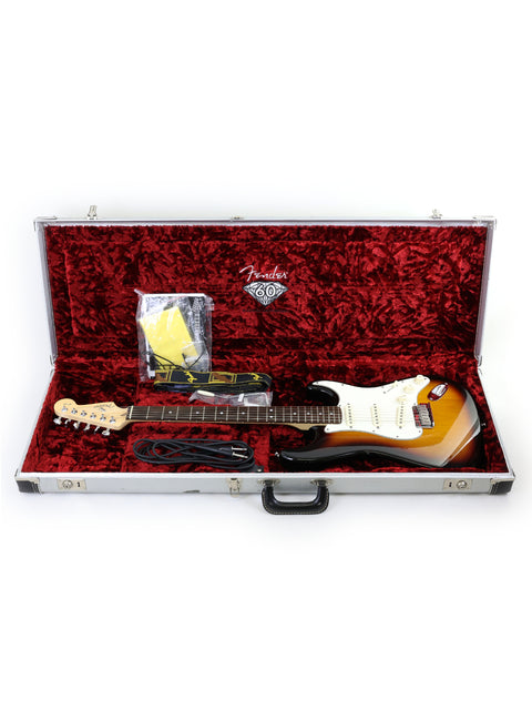 A guitar case opens to reveal a 2006 Fender 60th Anniversary American Stratocaster, highlighting its iconic shape.