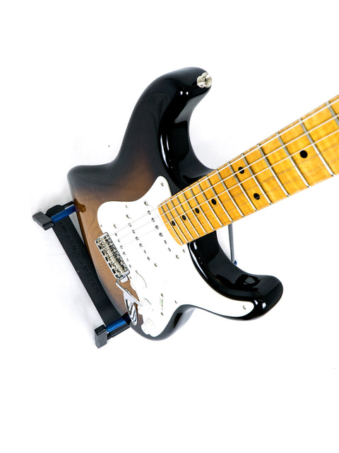 A guitar case with a sunburst electric guitar half out of it on a white background.
