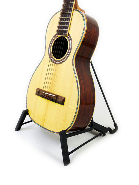 A guitar displayed on a stand with a clean white backdrop, highlighting its features. Captured in Gilet Bay State, Australia 2018.