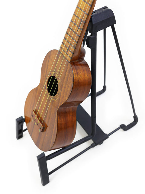 A historic Kaai Style 2 Koa Ukulele from Hawaii, c. 1918, positioned on a stand, highlighting its unique design.