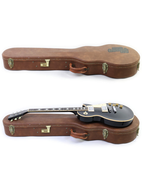A leather case holds two guitars, including a 1995 Gibson Les Paul Standard, highlighting their classic craftsmanship.