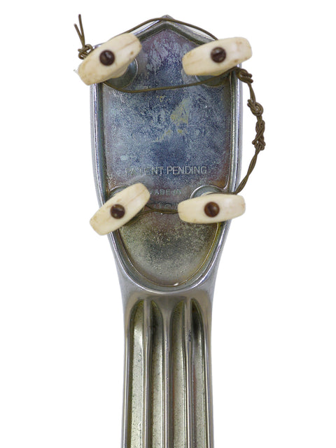 A metal fork with creative bead eyes and wire arms forming a whimsical face.