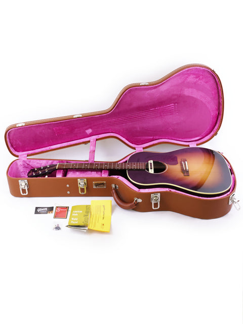 A pink guitar case showcases a Gibson J-45 True Vintage guitar, merging bold aesthetics with timeless musical quality.