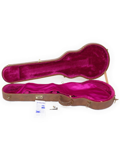 A pink guitar case with a soft pink lining, housing a Gibson Les Paul Custom, made in the USA in 1994.