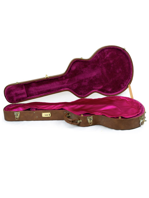 A pink velvet-lined guitar case, showcasing the signatures of BB King and Eric Clapton, made in the USA in 2000.