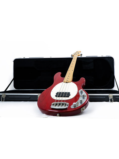 A red Music Man Stingray 4 H Bass guitar with its case, displayed on a white background.